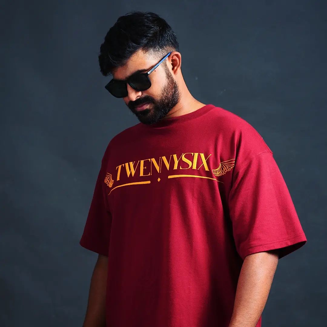 A model wearing the Twennysix Heavenly Hookup T-shirt in maroon, showcasing the captivating front design featuring the Twennysix emblem with angel wings