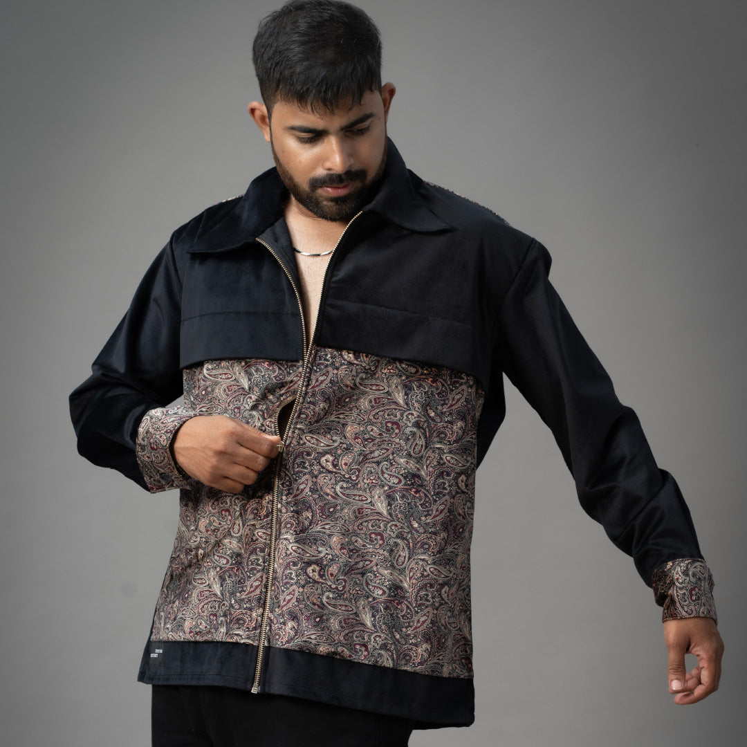 Model wearing Twennysix Velvet Blend Jacket, showcasing the front and cuffs adorned with intricate Kalamkari prints in brown, maroon, and dark colors. Jacket is black, adding elegance and sophistication to any ensemble.