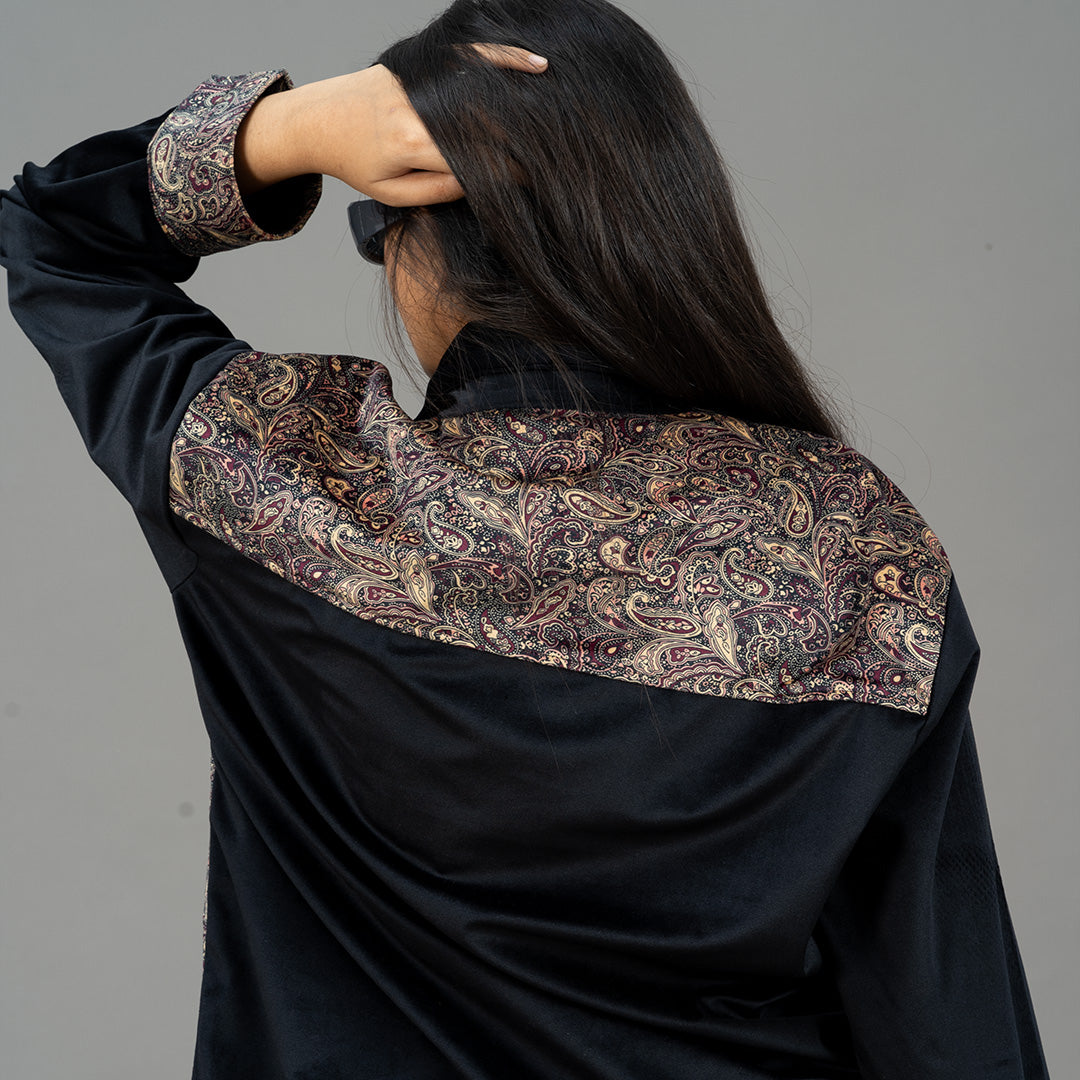 Back view of Twennysix Velvet Blend Jacket worn by female model, featuring Kalamkari print cuff and shoulder detail on black velvet fabric. Versatile unisex design adds sophistication to any outfit.