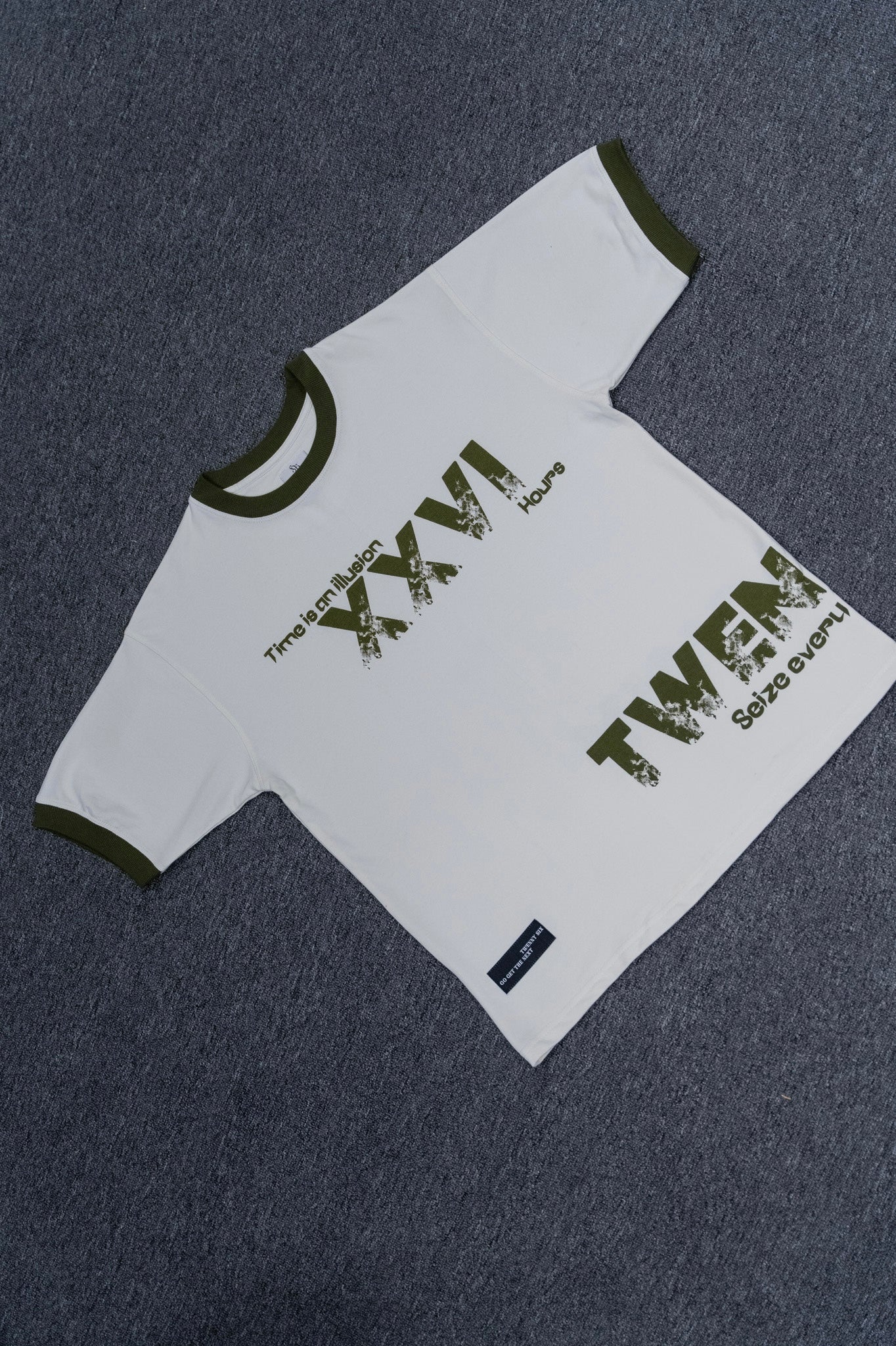 Flat lay of Twennysix XXVI Cotton T-shirt with empowering phrase 'Time is an illusion' and captivating XXVI emblem.