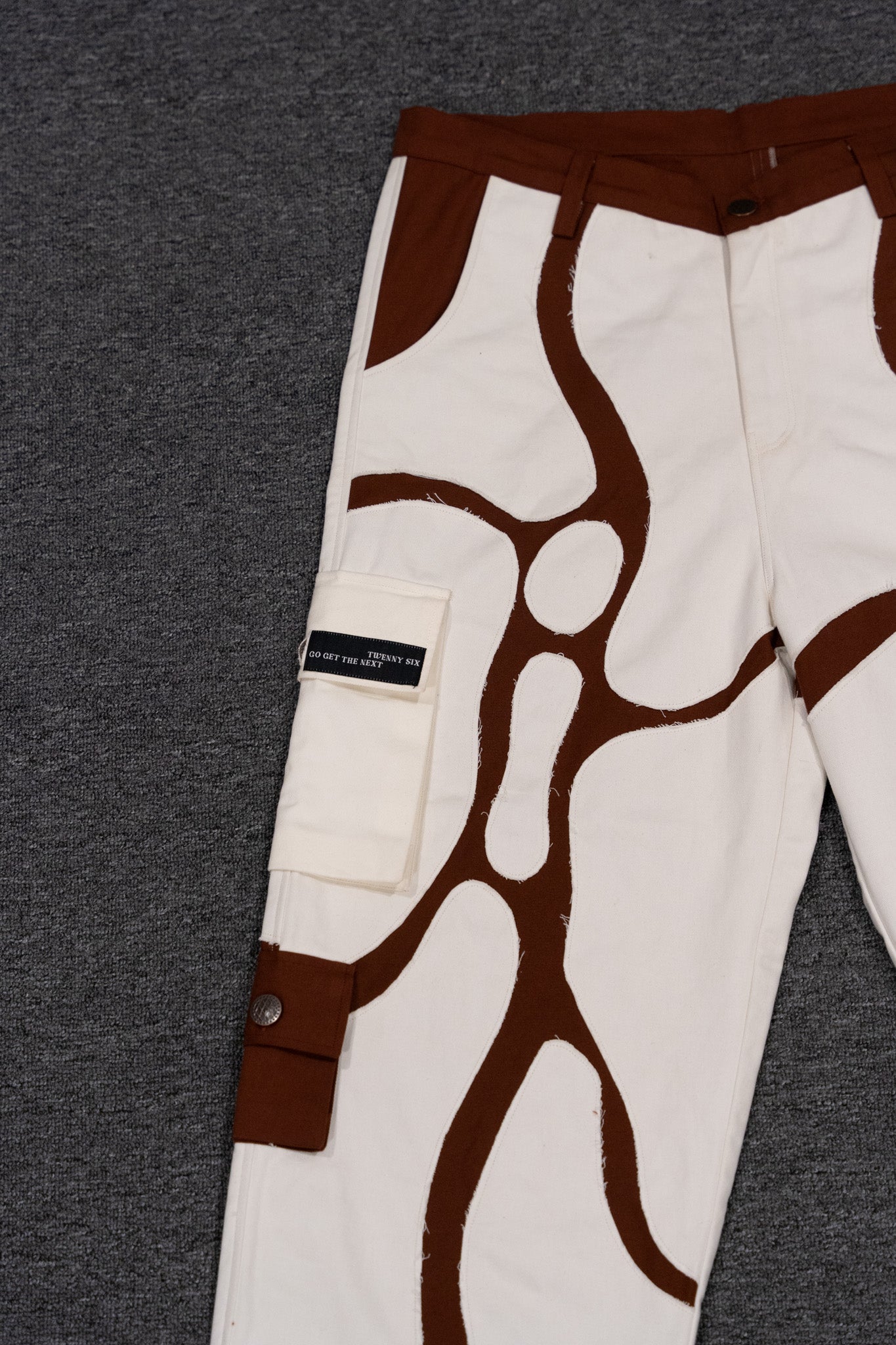 Close-up view of the MochaBlend Cargo Pant's hand-cut patches and rugged finish, highlighting its authentic design.