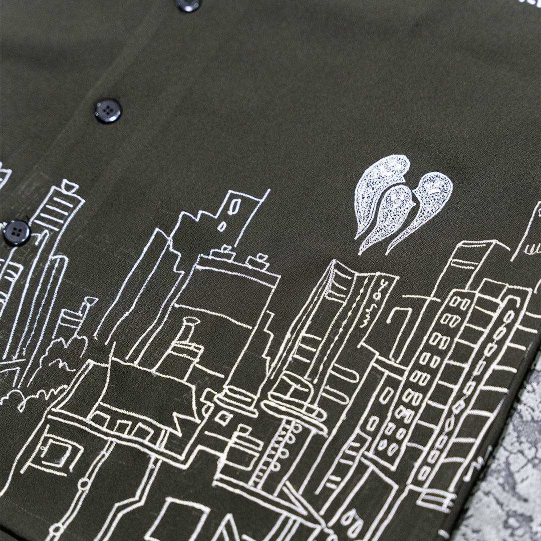 Flat lay close-up of Skyscraper Shirt with intricate building embroidery and three ghost motifs