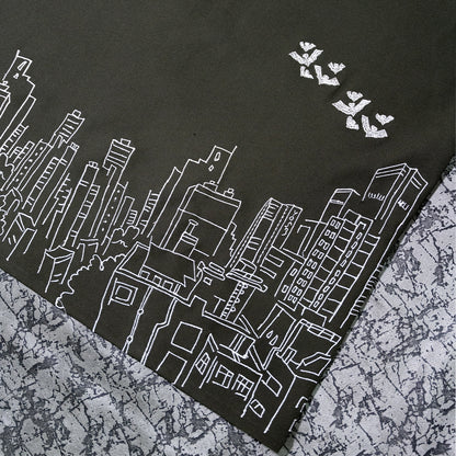 Close-up view of the intricate bat and building embroidery on the Skyscraper Shirt.