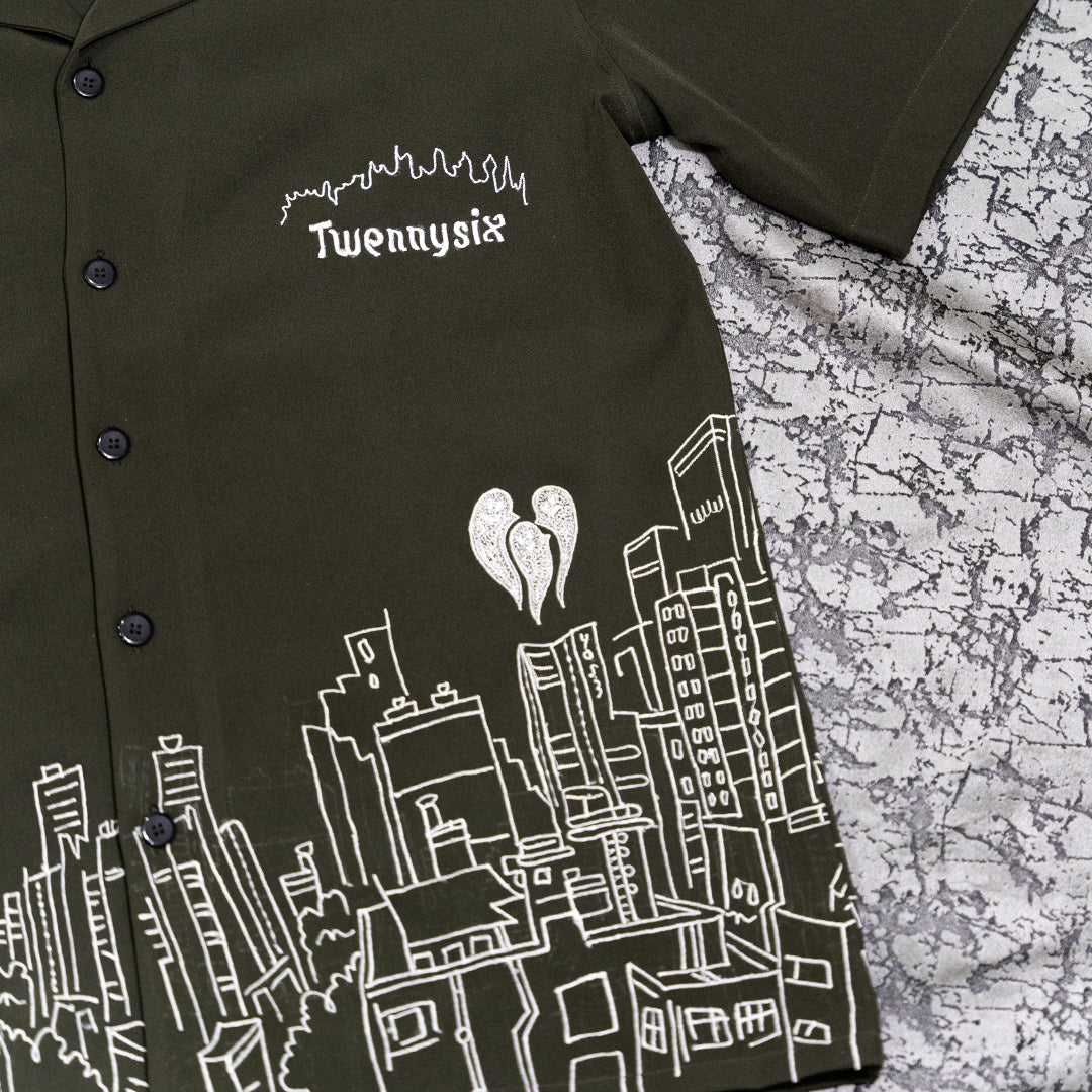 Flat lay close-up of Skyscraper Shirt with intricate building embroidery and three ghost motifs