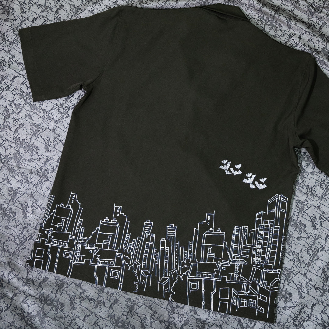 Backside flat lay of the Skyscraper Shirt displaying its intricate building embroidery and ghost motifs.