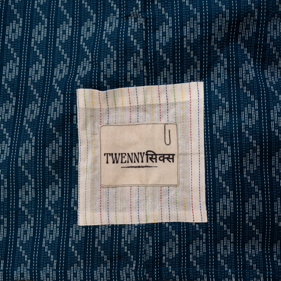 Close-up view of the white pocket with Twennysix patch on the blue wave Kantha shirt, showcasing intricate details.