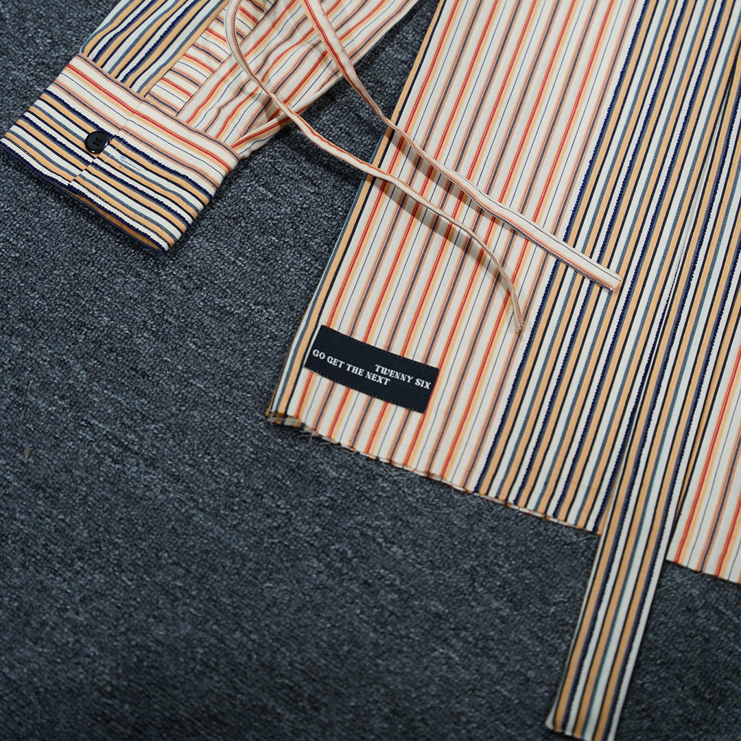 Close-up flat lay of the Stripey Blaze Shirt, showcasing the Twennysix badge and vibrant orange and white dobby stripe pattern.