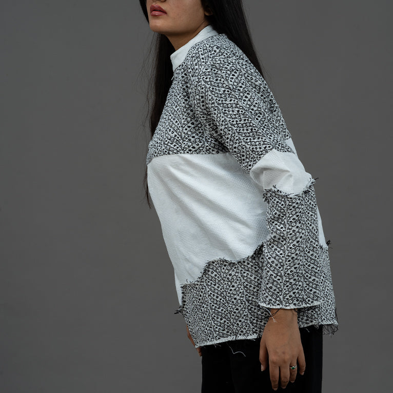 ide angle view of female model wearing the Slope Zip Jacquard Shirt, emphasizing the intricate design on the arms and sides.